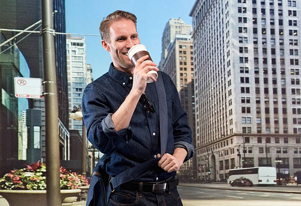 istock Smiling casual man having coffee in front of city 537548117