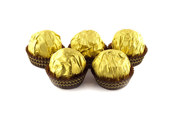 istock Chocolate balls wraped in the golden package isolated on white 537550929