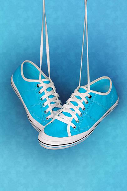 istock Pair of turquoise sneakers hangs on the laces. 537551437