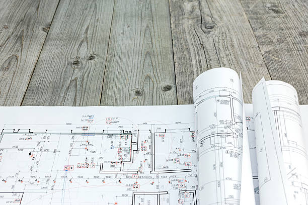 istock floor plan with rolls of architectural blueprints on wooden desk 537553024