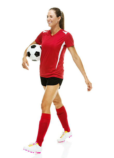 istock Cheerful female soccer player holding ball & walking 537586393