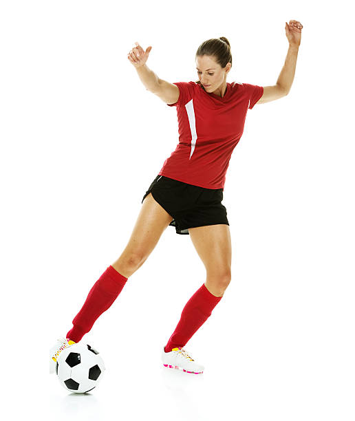 weibliche fußball spieler treten den ball - arms outstretched arms raised studio shot adult stock-fotos und bilder