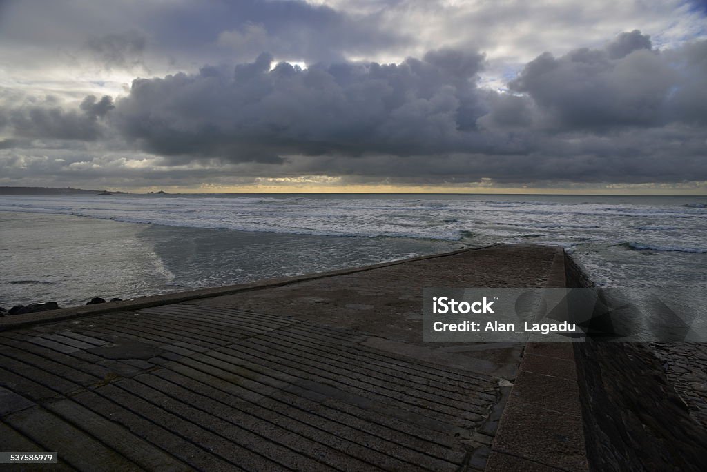 L'Ouziere slipway, St.Ouen, Jersey, U.K. Wide angle image of a slipway to the sea with dramatic Winter skies. 2015 Stock Photo