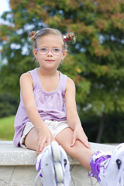 The happy toddler is sitting on the sofa outside.