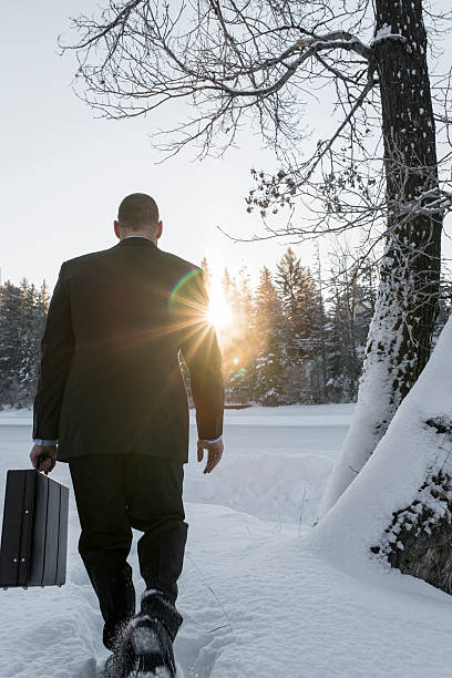 istock Businessman walks through deep snow, sunrise 537587707