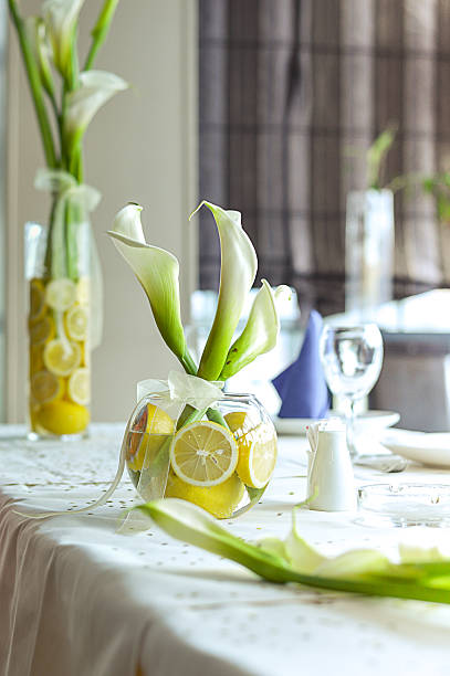 Bouquet of beautiful eustoma flowers and grapes on white table in kitchen. Interior design