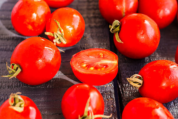 istock red juicy tomatoes cherry on dark wooden board 537597971