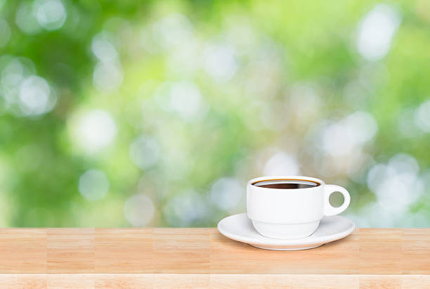 istock Coffee cup on the wooden table and green bokeh background 537599874