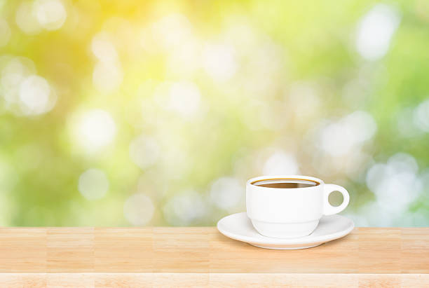 istock Coffee cup on the wooden table and green bokeh background 537599910