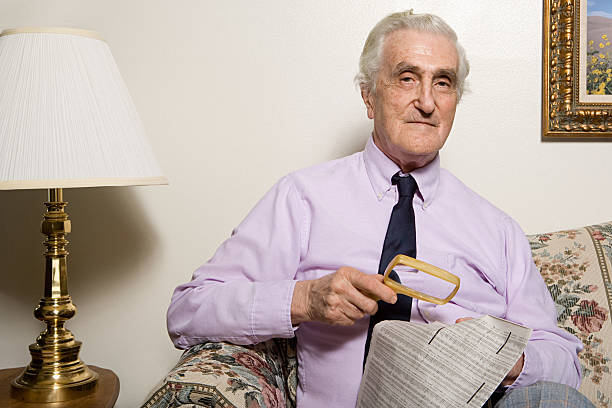 istock Man reading newspaper with magnifying glass 537599985