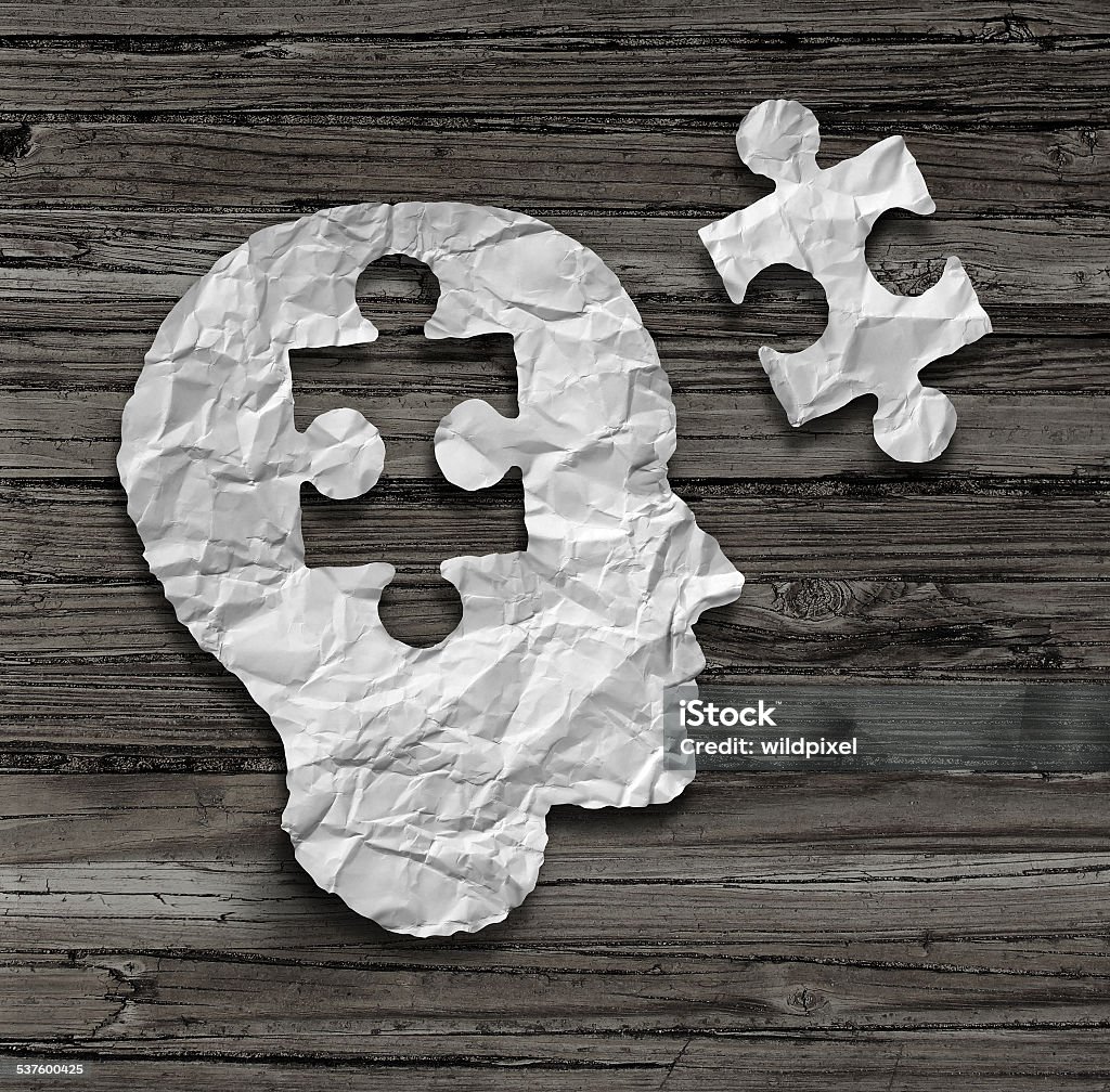 Puzzle Head Puzzle head brain concept as a human face profile made from crumpled white paper with a jigsaw piece cut out on a rustic old wood background as a mental health symbol. 2015 Stock Photo