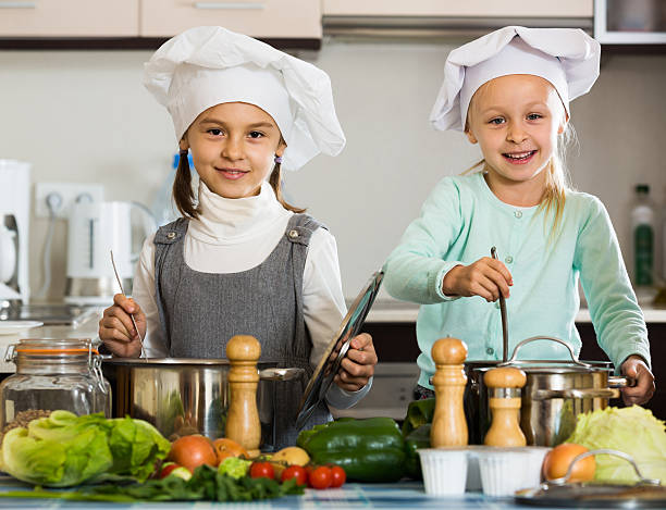 istock Two girls preparing vegetables and smiling indoors 537600428