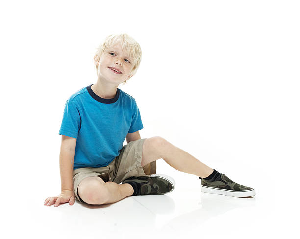 istock Smiling little boy sitting on floor and looking away 537601452