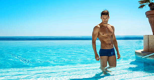 мышечная парень в бассейн позировать летом пейзаж - male men tan chest стоковые фото и изображения