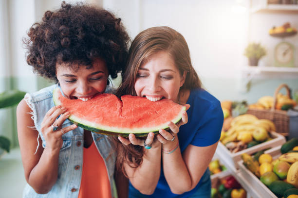 istock Two young woman eating watermelon and having fun 537608900