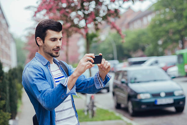 istock young man taking a photo with his phone 537609266