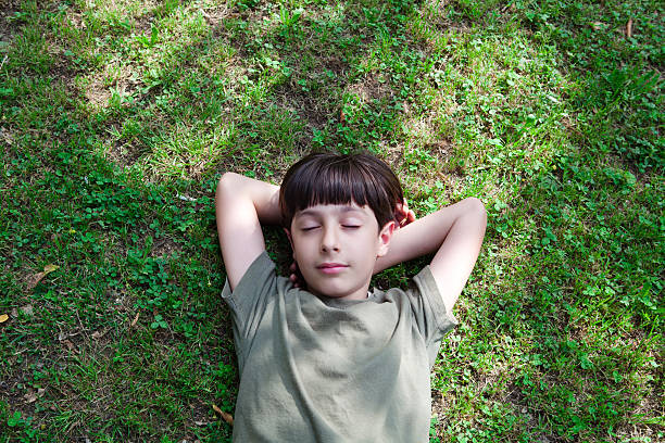 istock Child Lying Down in the Grass, Closed Eyes, Dreaming 537611919