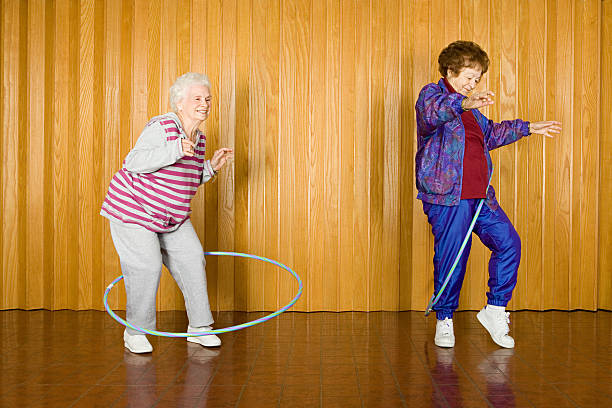 Two senior women exercising with hula hoops