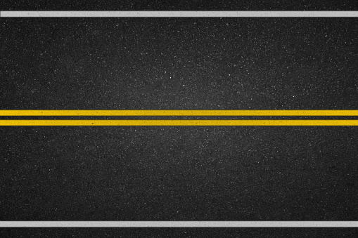 Dobles líneas amarillas en carretera asfaltada photo