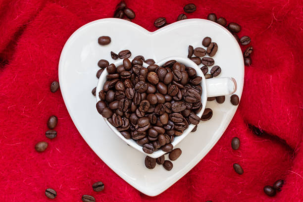 istock Heart shaped cup with coffee beans on red 537615589
