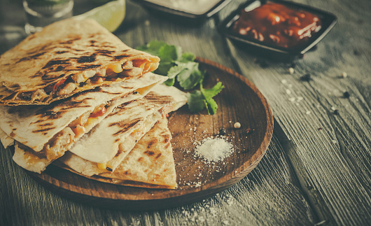 Quesadilla on aged wooden table. Stock photo