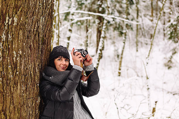 istock Girl near a tree in the winter forest 537616833