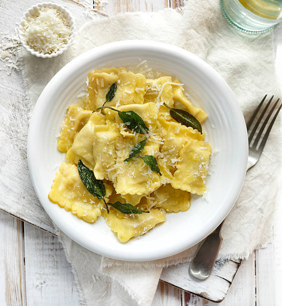 Ravioli with sage butter sprinkled with grana padano cheese Traditional Italian meal, ravioli with sage butter grana padano stock pictures, royalty-free photos & images