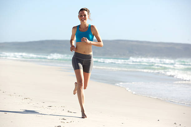 istock Young sportswoman jogging along the seashore 537619078