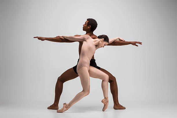 par de bailarines de ballet posando sobre fondo gris - contemporary ballet fotografías e imágenes de stock