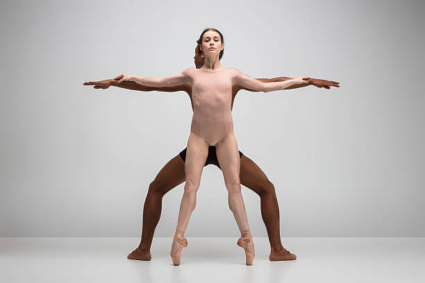 ein paar ballett-tänzer posieren auf grauem hintergrund - beautiful ballet dancer adult ballet stock-fotos und bilder