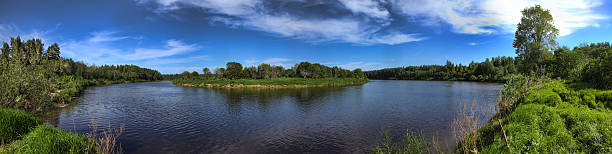istock Wide panorama of a river and the forested mountains 537621304