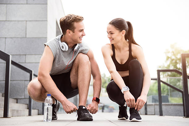 istock Couple squatting and tying their shoelaces 537625014