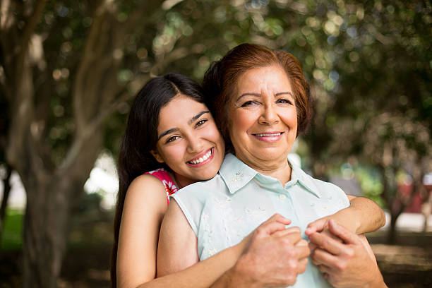 Granddaughter holding her grandmother tight A beautiful granddaughter holding her grandmother tight in this horizontal shot. mexican ethnicity photos stock pictures, royalty-free photos & images