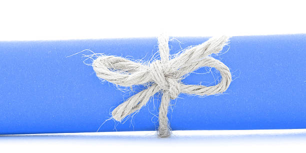 istock Handmade natural rope knot tied on blue paper roll isolated 537630868
