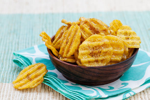 istock Dried dehydrated deep fried banana chips in a wooden bowl 537633308