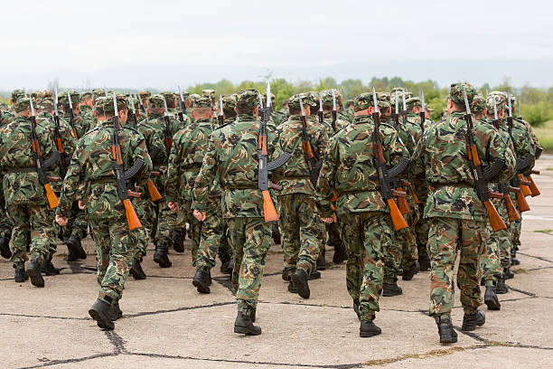 Sofia, Bulgaria - May 4, 2016: Soldiers from the Bulgarian army are preparing for a parade for Army's day in uniforms with Kalashnikov AK 47 rifles. Seen from thei backs. Unrecognisable people.