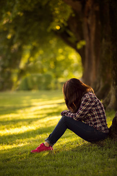 istock beautiful young women sitting in a park 537635940
