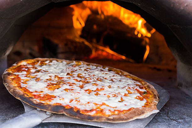 istock Mozzarella and Basil pizza coming out of wood burning. 537640141