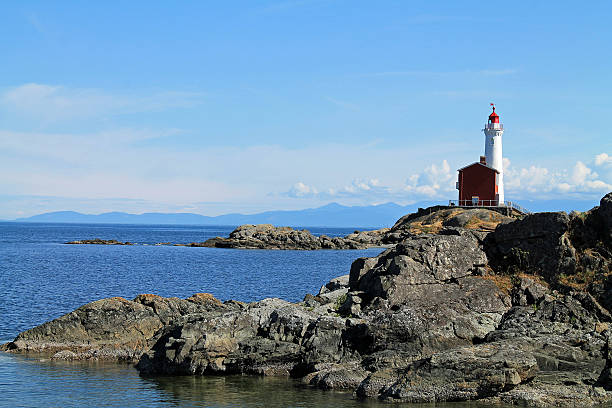 istock Red and White Lighthouse on a Rocky Coast 537640298