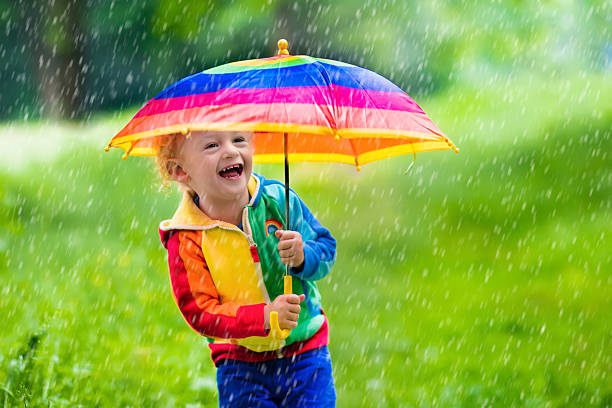 istock Beautiful child playing in the rain 537640634