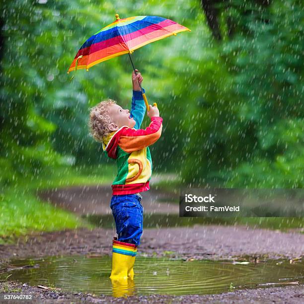 Little Child Playing In The Rain Stock Photo - Download Image Now - Rain, Toddler, Child