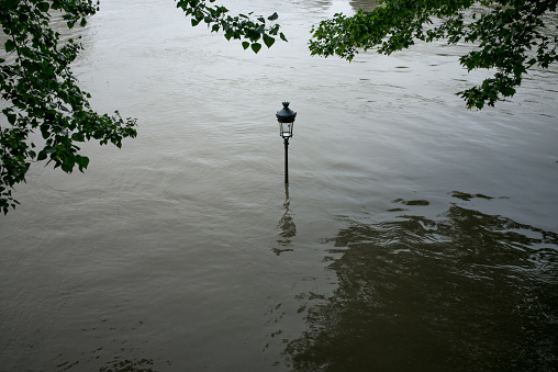 Street lamp in the Ile Saint-Louis immersed in water with the Seine flooding. Paris, France. Black and white