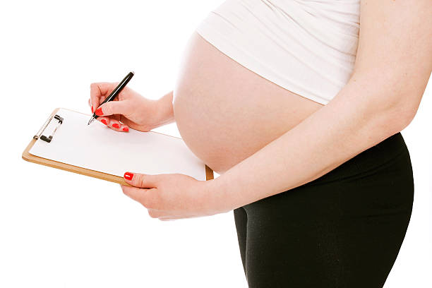 istock Pregnant woman showing folder or tablet with blank 537644966