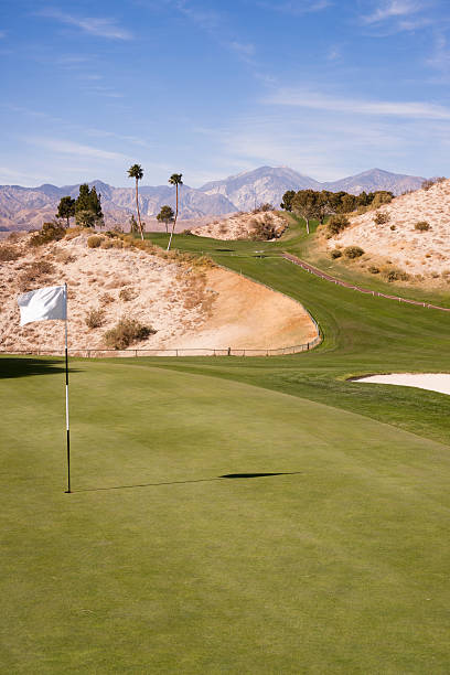 чаша флаг гольфа зеленый пустынный палм спрингс вертикальные горы - lawn desert golf california стоковые фото и изображения