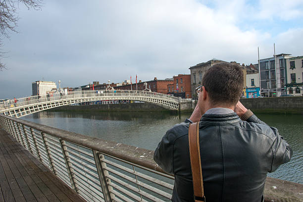 turista tomando puente de ha'penny en dublín. - dublin ireland urban road people real people fotografías e imágenes de stock