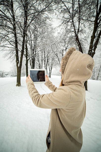 istock Woman taking picture using digital tablet-Snowing winter day 537666069