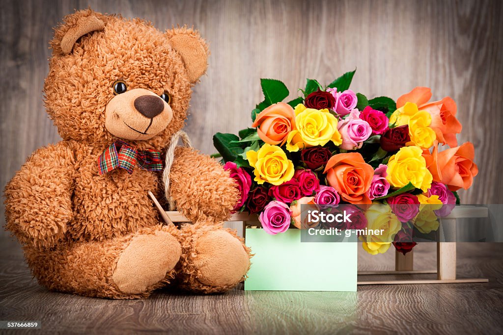 Bunch of roses and a teddy bear Bunch of roses and a teddy bear on wooden background 2015 Stock Photo