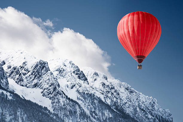 Balloon over winter landscape Colorful hot-air balloon flying over snowcapped mountain inflating photos stock pictures, royalty-free photos & images