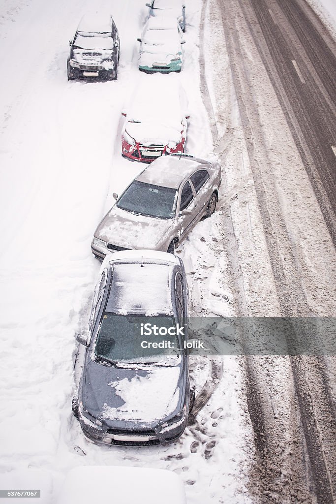 Snow-covered cars on the roadside Snow-covered cars during a snowfall 2015 Stock Photo