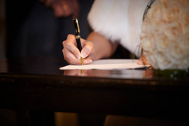 Bride hand with a pen signing wedding license